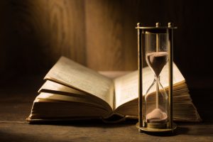 sandglass,with,open,ancient,book.,study,of,literature,,history,,culture.
